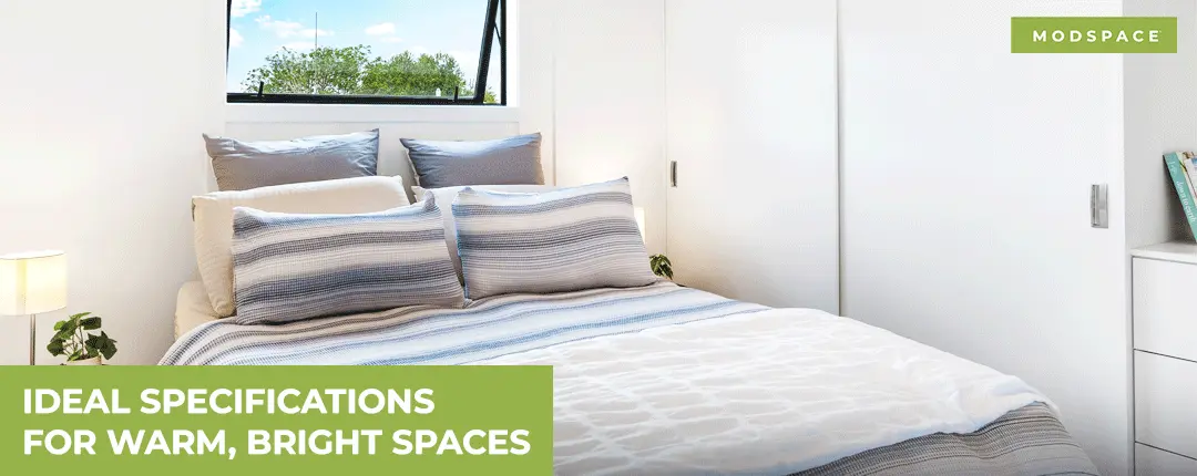 A bright, modern bedroom inside a Modspace modular home featuring an open awning window for ventilation and efficient built-in storage, illustrating ideal specifications for creating warm, light-filled spaces in NZ.
